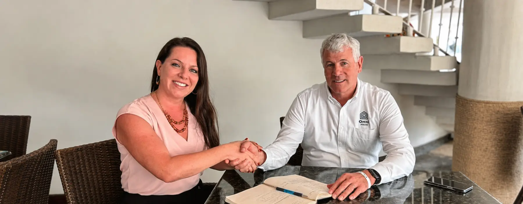 Stephen Yeager estrechando la mano de una profesional inmobiliaria durante una reunión de Omni